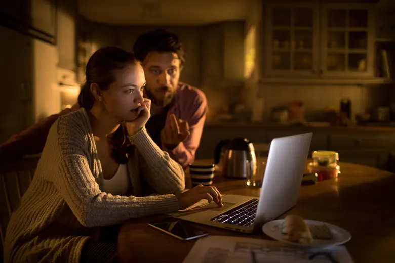 Pár se snaží přes laptop během výpadku elektřiny